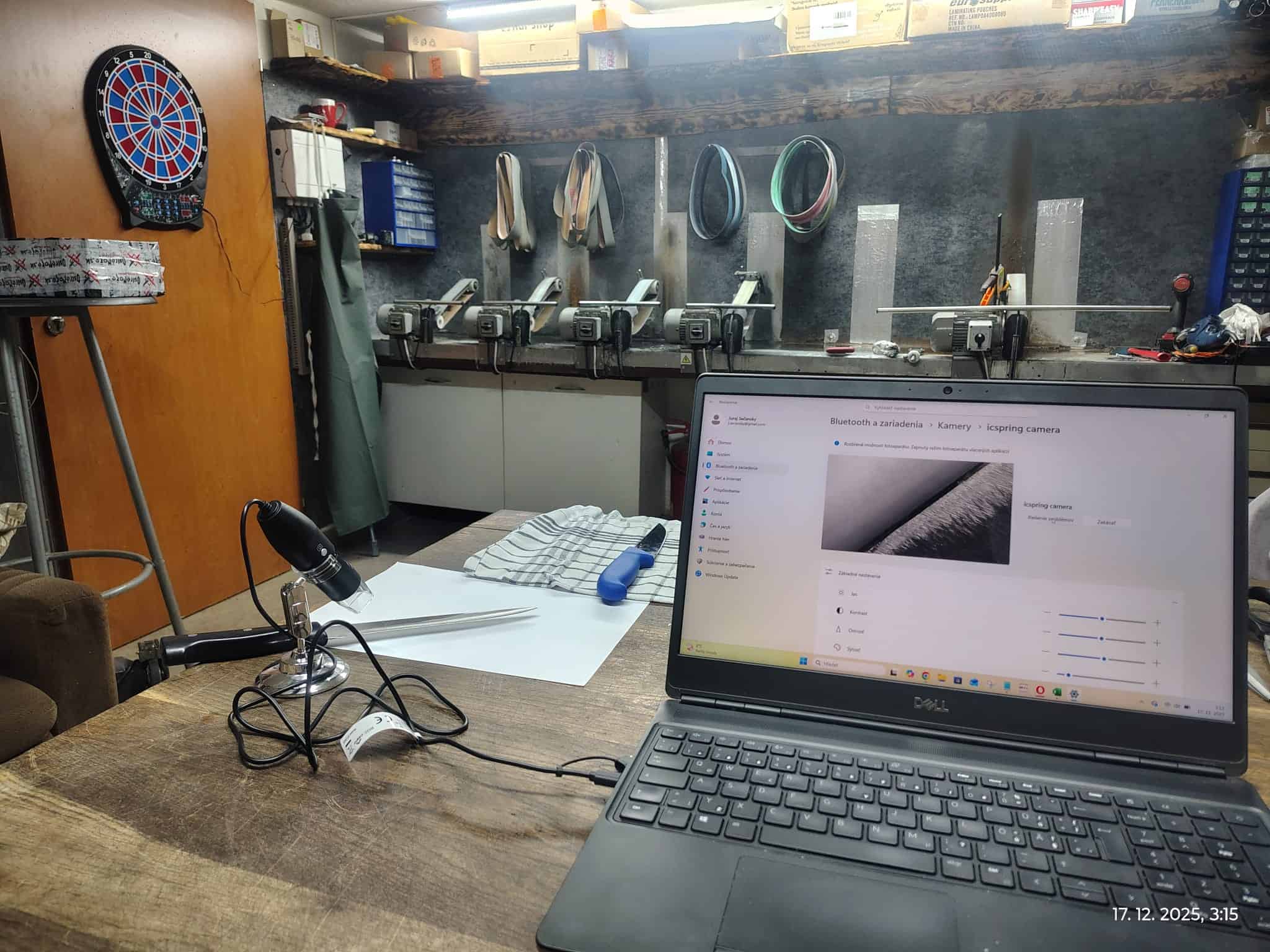 Pracovné miesto s mikroskopom a notebookom pri kontrole ostria noža